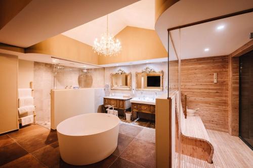 a bathroom with a large sink and a large mirror at Le Hameau Des Pesquiers Ecolodge & Spa, Curio Collection By Hilton in Hyères