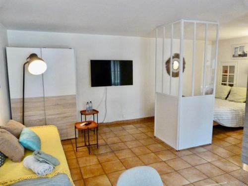 - un salon avec un canapé jaune et une télévision dans l'établissement Loft parc Jourdan stationnement à proximité, à Aix-en-Provence