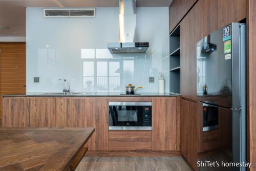 a kitchen with wooden cabinets and a stainless steel refrigerator at Pentstudio 1a in Hanoi