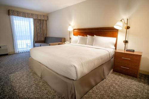 a hotel room with a large bed and a couch at The Yankee, Trademark Collection by Wyndham in Lenox