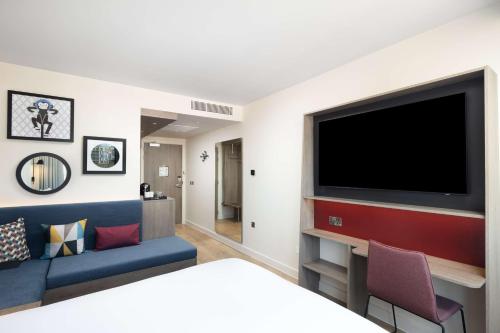 a living room with a large flat screen tv at Hampton By Hilton London City in London