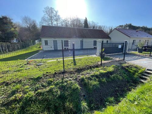 une maison avec une clôture devant une cour dans l'établissement Gîtes Le Duo de Galerne , à 5 minutes du Zoo Parc de Beauval, à Seigy