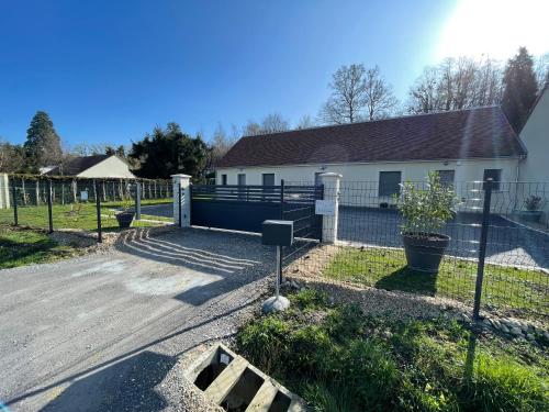 une maison avec une clôture devant une cour dans l'établissement Gîtes Le Duo de Galerne , à 5 minutes du Zoo Parc de Beauval, à Seigy