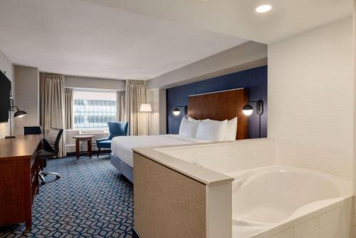 a hotel room with a bed and a bath tub at Wyndham Grand Fallsview Hotel in Niagara Falls