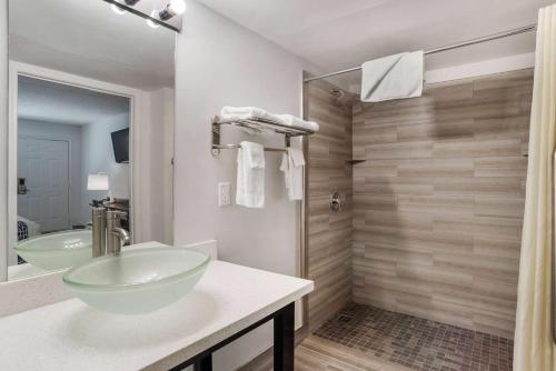 y baño con lavabo de cristal y ducha. en Super 8 by Wyndham Daleville-Fort Novosel, en Daleville