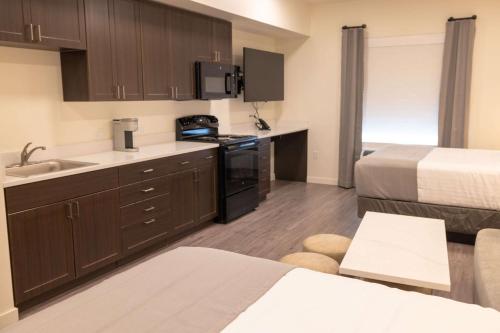 a small kitchen with a sink and a bed at Hawthorn Extended Stay by Wyndham Jackson Alpine in Alpine