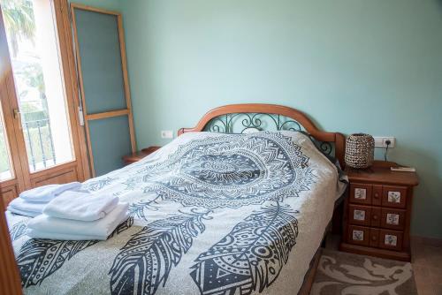 ein Schlafzimmer mit einem Bett mit einer schwarzen und weißen Decke in der Unterkunft Puerta del Mar in Calpe