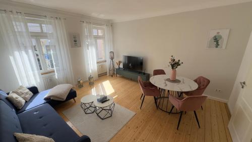 a living room with a blue couch and a table at Design Apartment Hindenburg in Neustadt an der Weinstrasse in Neustadt an der Weinstraße