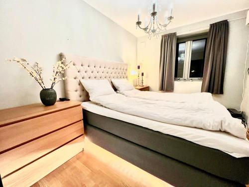a bedroom with a large white bed with a chandelier at Panorama Storelva in Tromsø