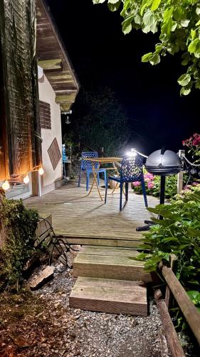 - une table et des chaises sur une terrasse la nuit dans l'établissement la chambre d hotes de marie indépendante et sa terrasse avec vue panoramique proche alpes mancelles, à Sillé-le-Guillaume