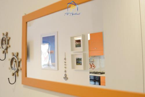 a mirror hanging on a wall in a kitchen at Blu Celeste - by AP Apartment in Baia Verde