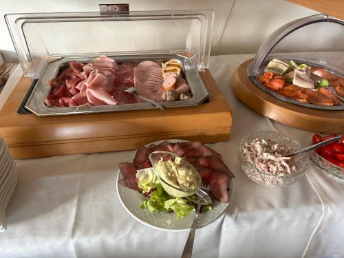 a table topped with a container of meat and vegetables at Hotel Berg in Dannenfels