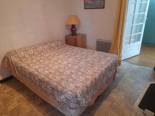 - une chambre avec un lit, une lampe et une porte dans l'établissement Maison Joséphine, à Valras-Plage