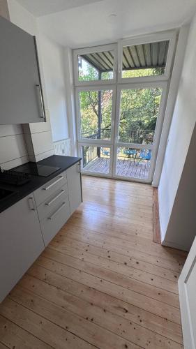 a kitchen with a large window and a wooden floor at Design Apartment Hindenburg in Neustadt an der Weinstrasse in Neustadt an der Weinstraße