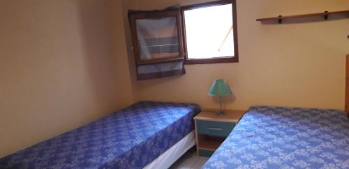 une chambre avec deux lits et une fenêtre dans l'établissement Les Mers du Sud, 4 personnes, vélos, piscine, climatisation, plage à 120m, à Gruissan