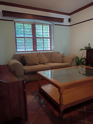a living room with a couch and a coffee table at Berg en Zee Guesthouse in Gordonʼs Bay
