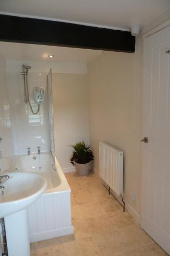 a bathroom with a sink and a bath tub at Beautiful Dartmoor cottage overlooking vineyard in Bridford