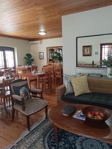 a living room with a couch and a table at Berg en Zee Guesthouse in Gordonʼs Bay