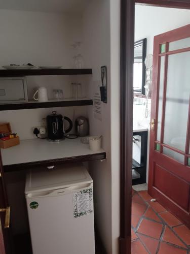 a small kitchen with a counter and a refrigerator at Berg en Zee Guesthouse in Gordonʼs Bay