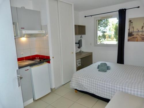 Cette petite chambre comprend un lit et une cuisine. dans l'établissement Le clos d'AIX Célony N 2 Parking Piscine Clim, à Aix-en-Provence