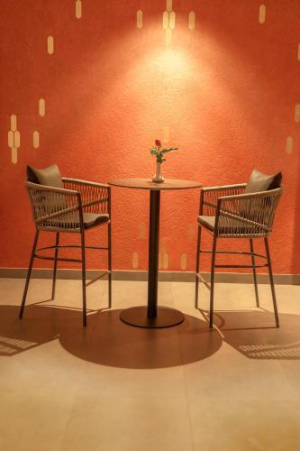 two chairs and a table with a vase on it at VSC Porto Marina in Bālarāmpuram