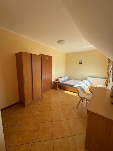 a small room with a bed and a desk at Willa 56 in Międzyzdroje