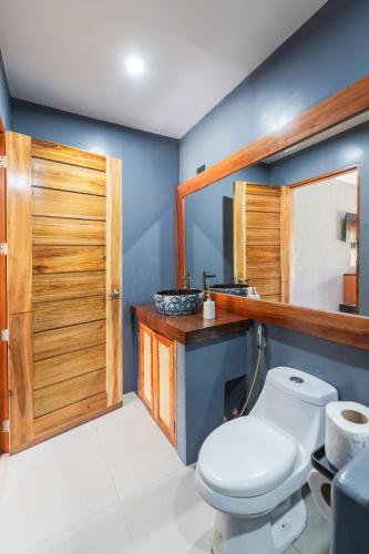 a bathroom with a toilet and a wooden door at Casa de loren- generator and starlink in General Luna