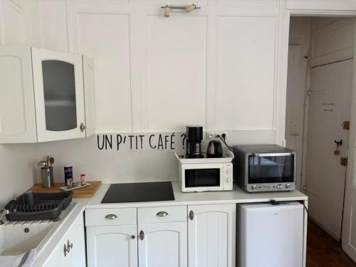 La cuisine est équipée de placards blancs, d'un four micro-ondes et d'appareils électroménagers. dans l'établissement Dieppe Coeur de Ville, à Dieppe