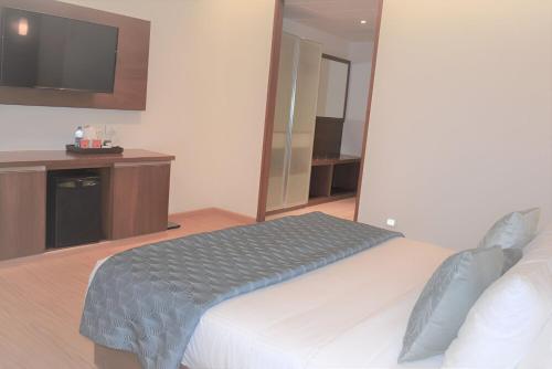 a bedroom with a white bed and a television at Fortune Park Airport Road, Hubballi - Member ITC Hotels' Group in Hubli