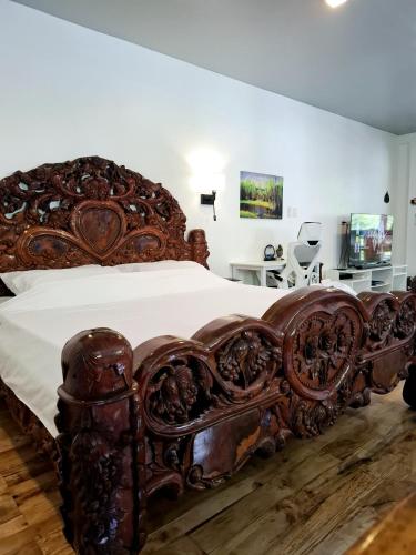 ein großes Holzbett in einem Schlafzimmer mit einer weißen Wand in der Unterkunft Casaroro Residence in Valencia