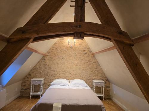 une chambre avec un lit dans un grenier dans l'établissement La Maison De Jade, à Meyrals