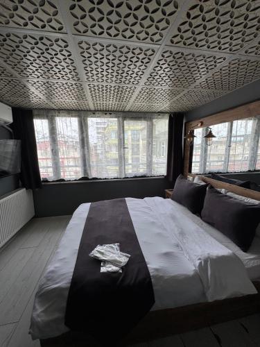 a bedroom with a large bed in a room with windows at deperlas in Atakum