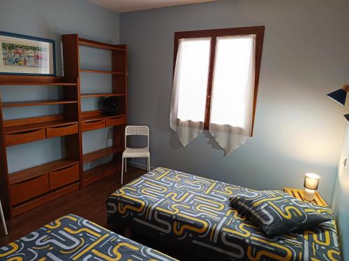 ein Schlafzimmer mit zwei Betten und einem Fenster in der Unterkunft Maison de la famille et des amis in Biscarrosse