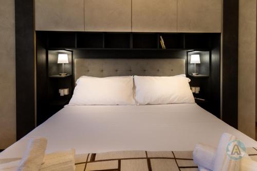 a bed with two white pillows and two lights at Appartamento in Residence La Playa in Silvi Marina