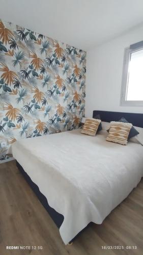 un lit avec deux oreillers dessus dans une chambre dans l'établissement Les Palmiers Appartement 4 personnes 50m De La Plage Parking, à Canet