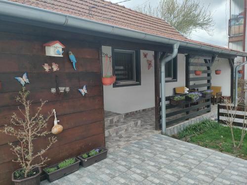a house with a wooden wall next to a patio at Miris Proleća in Rekovac