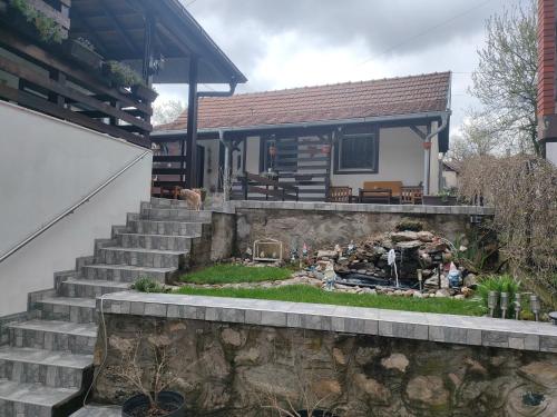 a small house with a stone wall and stairs at Miris Proleća in Rekovac