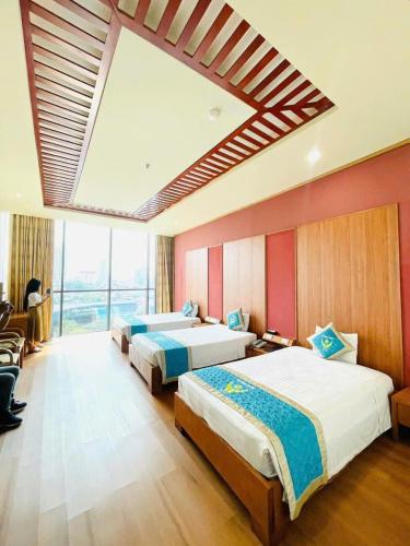 a bedroom with two beds and a large window at Khách Sạn Hoàng Mấm Minh Cầu - Best City view in Thái Nguyên