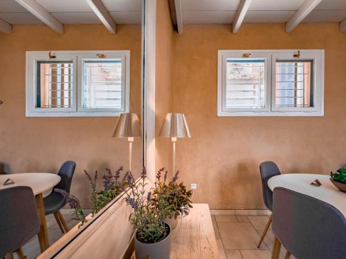 un restaurante con 2 mesas y sillas y 2 ventanas en Dreaming of Tuscany, en Aegina Town