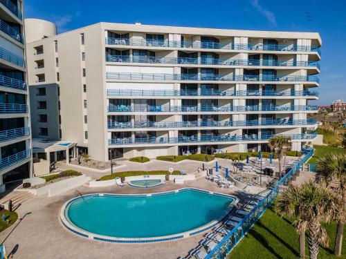 an apartment building with a pool and a resort at Ebb Tide 703 in New Smyrna Beach