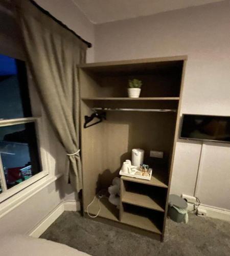 a book shelf in a bedroom with a window at OYO The Castlegate Arms in Penrith