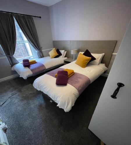 two beds sitting in a room with a window at OYO The Castlegate Arms in Penrith