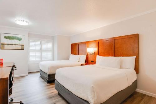 a hotel room with two beds and a desk at Ramada by Wyndham Mountain View in Mountain View