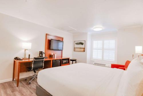 a bedroom with a bed and a desk with a computer at Ramada by Wyndham Mountain View in Mountain View