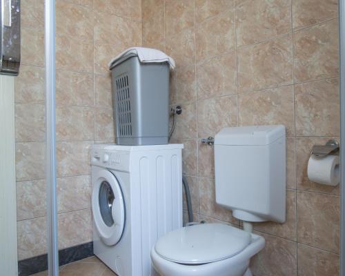 a bathroom with a toilet and a washing machine at Luxury Apartments Montesan in Sveti Stefan