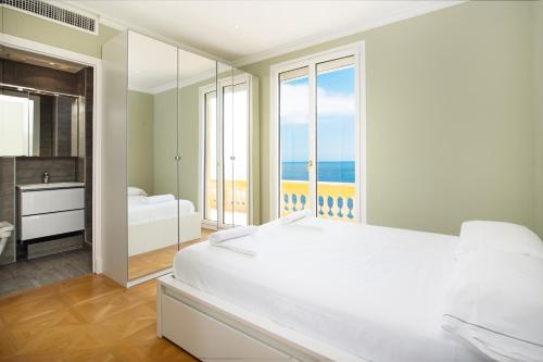 a white bedroom with a view of the ocean at CAP D'AIL - SEAFRONT LUXURY PENTHOUSE few minutes from Monaco in Saint-Antoine