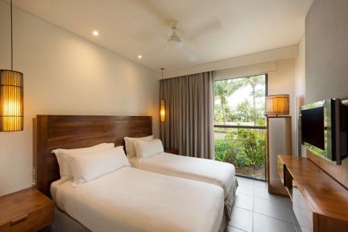 a hotel room with two beds and a television at Hilton Fiji Beach Resort and Spa in Denarau