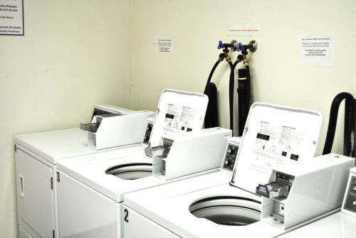 a laundry room with three washing machines in it at Travelodge by Wyndham Langley in Langley