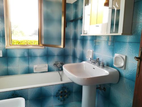 a blue tiled bathroom with a sink and a mirror at Villa Maddalena a Otranto in Otranto