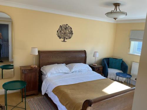 a bedroom with a bed with a tree on the wall at Peaceful house ideal for dogs lovely location in Aldeburgh